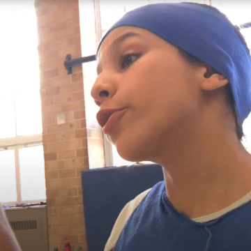 Une fille jouant la joueuse de basket qui lève le doigt pour affirmer que son équipe est la meilleure