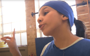 Une fille jouant la joueuse de basket qui lève le doigt pour affirmer que son équipe est la meilleure