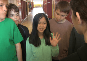 Jeune fille protestant de la main dans un couloir d'école