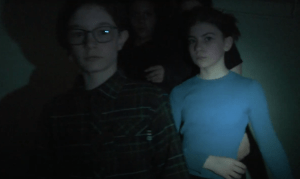 3 silouettes d'enfants avancant dans le noir