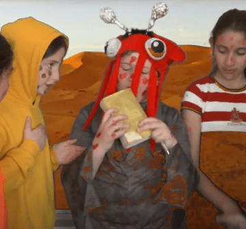 5 enfants costumés en jaune et orange et avec des picots de couleur sur le visage.