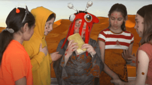 5 enfants costumés en jaune et orange et avec des picots de couleur sur le visage.