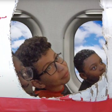 3 garçons dans un décor de carton d'avion