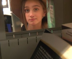 Fille regardant à travers un rayon de bibliothèque
